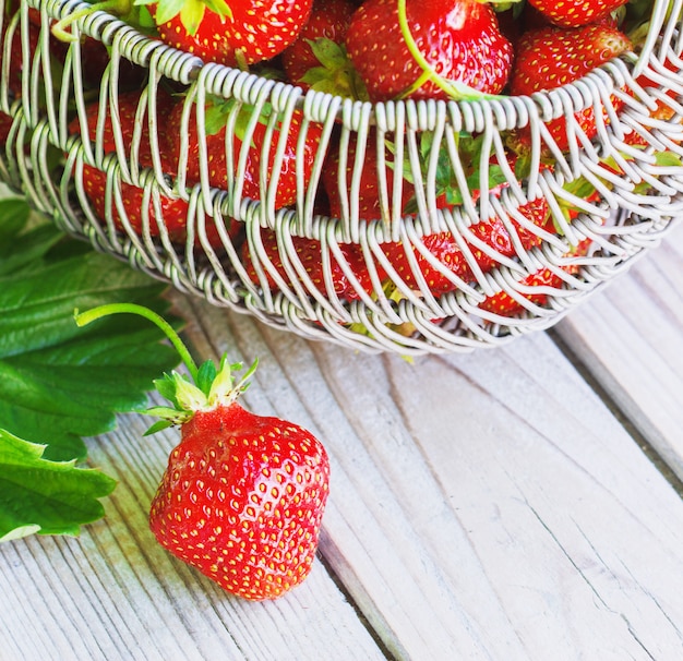 Sappige verse aardbeien in een mand op witte houten, selectieve nadruk