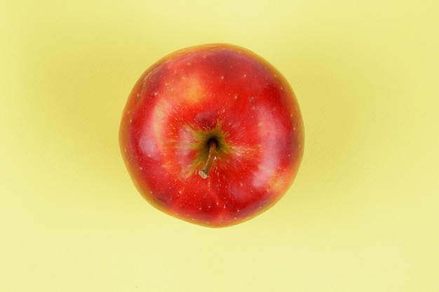 Sappige zoete hele rode appel op een gele achtergrond Gezonde voeding concept Close-up van een rood fruit