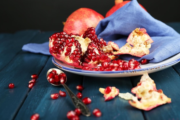 Saprijke rijpe granaatappels op een houten tafel op een donkere achtergrond