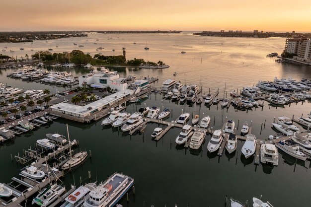 Foto sarasota florida bij zonsondergang luxe jachten aangemeerd in sarasota bay marina amerikaanse stad downtown architectuur met hoge kantoorgebouwen usa reisbestemming