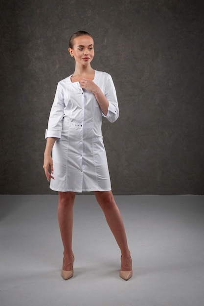Saratov Rusland 7202022 Medische kleding wit op het meisjesmodel Kledingconcept voor arts en verpleegster op een donkergrijze neutrale achtergrond