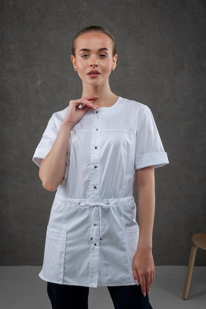 Saratov Russia 7202022 Medical clothes white on the girl model Dress concept for doctor and nurse on a dark gray neutral background