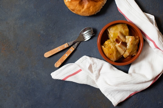 Sarma - traditional dish of Balkan cuisine. Cabbage rolls with meat and rice, served with bread. Balkan cuisine. Serbian cuisine. Dark background. Top view. Space for text