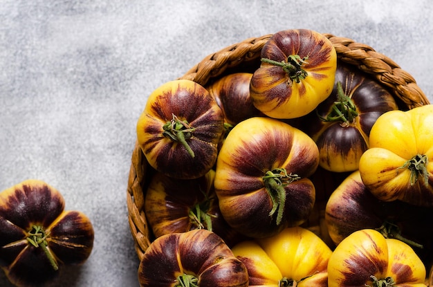 Sart roloise tomaten in een mand op een grijze achtergrond