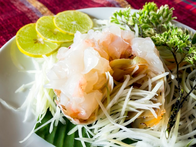 Sashimi kreeft, Japans eten. Close-up van verse rauwe kreeft serveren met gesneden citroen op witte schotel.