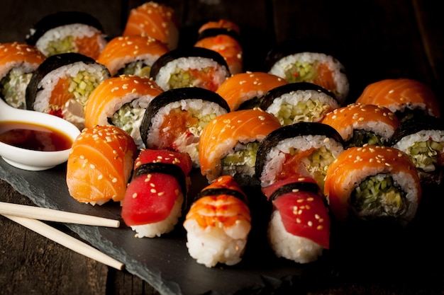 Sashimi and sushi rolls on a stone board