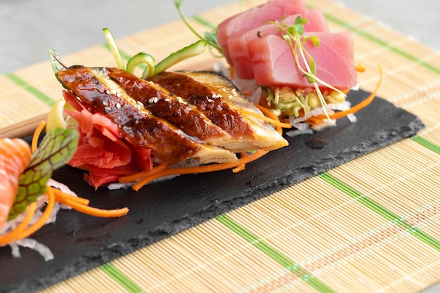 Сашими суши из лосося, угря и тунца на тарелке