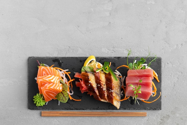Sushi di sashimi di salmone, anguilla e tonno servito sul piatto