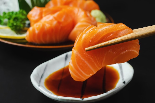 Sashimi Zalm Japans eten eetstokjes en wasabi op de zwarte tafelxAxA