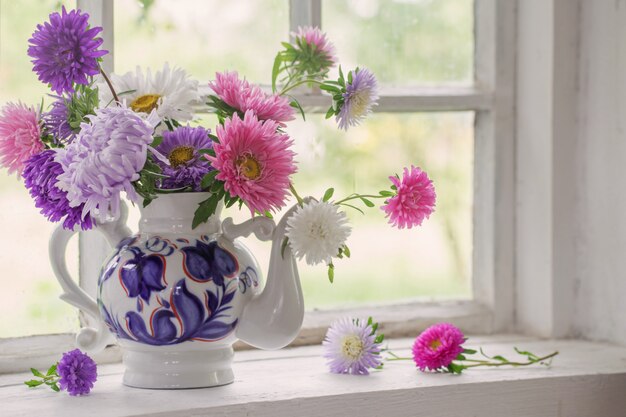 Sasters in teapot on windowsill