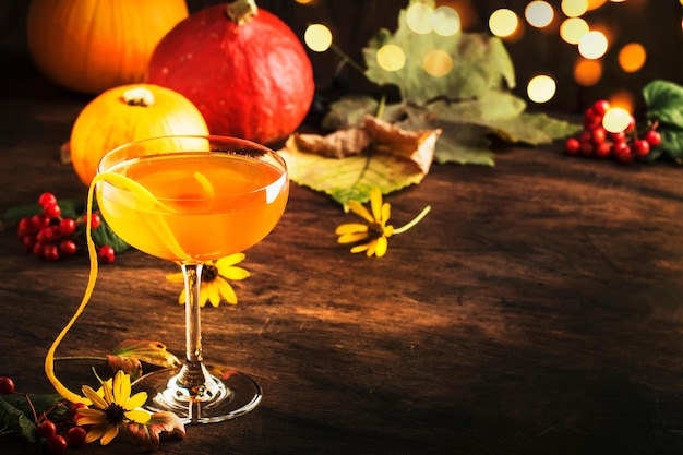 Фото Коктейль на хэллоуин с усами сатаны с джином, вермутом, апельсиновым соком и ликером, винтажный темный деревянный