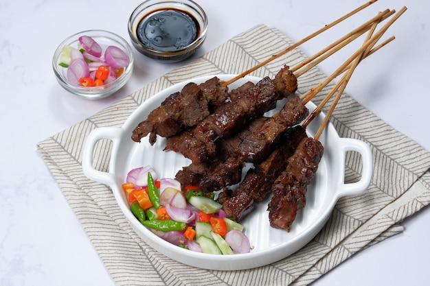 satay or sate skewered and grilled meat, served with spicy salad ,cucumber,chili and soy sauce,