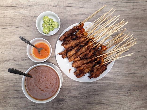 Sate ayam chicken satay served with peanut sauce chili sauce\
and lime one of the popular indonesian cuisine