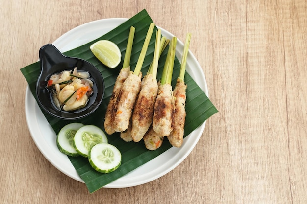 Sate lilit, traditional balinese minced chicken satay with\
lemongrass as skewer, served with sambal