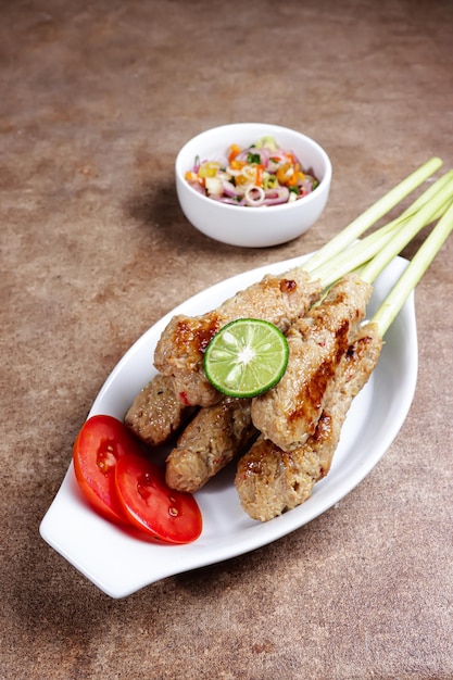 Sate lilit traditional balinese minced seafood or chicken satay\
with lemongrass as aromatic skewer