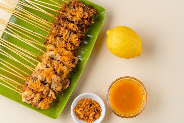 Sate taichan or Taichan satay with grilled chicken skin served with chili sauce