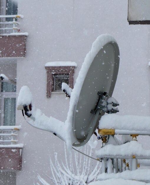 Satellite antenna under the snow on the roof snow accumulated on the roof in winter snowstorm