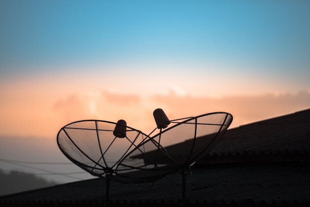 Photo satellite dish or antenna dish on the house roof with beautiful blue sky in the morning.