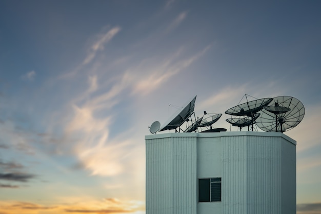 Спутниковая антенна на крыше здания с красивым небом