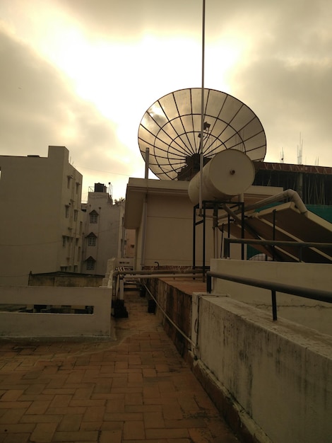 Foto anello satellitare sulla terrazza dell'edificio contro il cielo