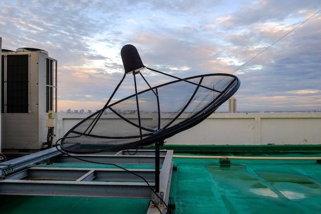 Satellite dish receiver and Air Conditioning stand on the rooftop of the building.