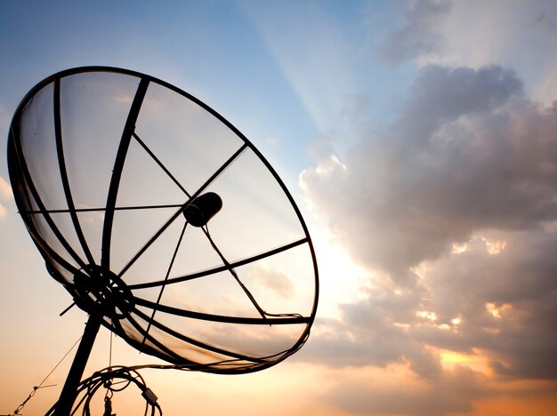 Satellite dish over sunset sky