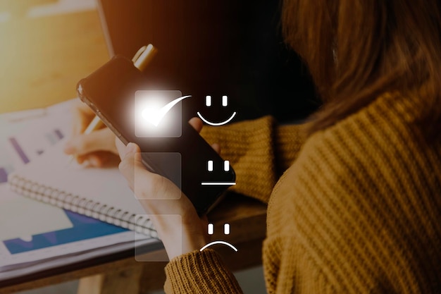 Satisfaction and customer service concept business people are\
touching the virtual screen on the happy smiley face icon to give\
satisfaction in service rating very impressed