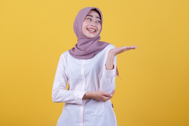 Hijab를 입고 손에 뭔가 들고 만족 된 매력적인 여자