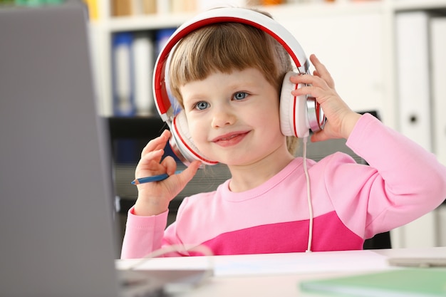 Satisfied child in headphones sitting