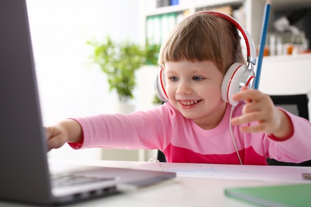 Satisfied child in headphones sitting