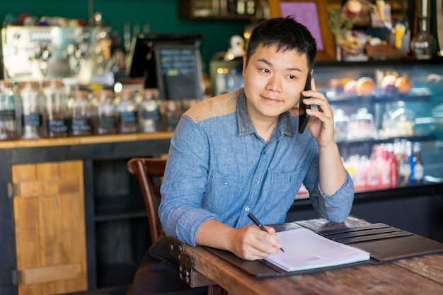 Satisfied entrepreneur solving company issues on mobile phone.