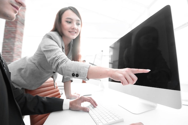 Satisfied girl is pointing at a blank monitor screen