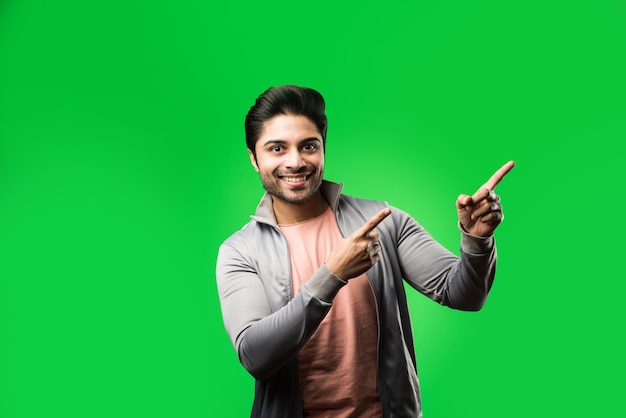 Satisfied Indian Man presenting, pointing, displaying or advertising with empty hands or fingers. standing isolated