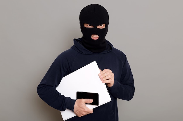 Satisfied man robber steals laptop beech and phone