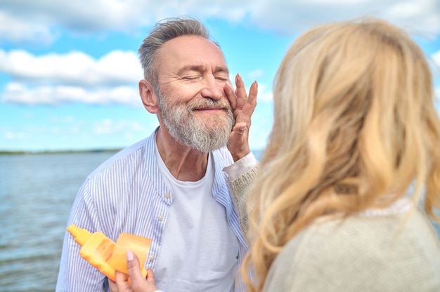 Satisfied man with closed eyes and woman touching hand