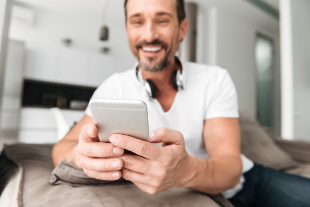 Satisfied mature man holding mobile phone