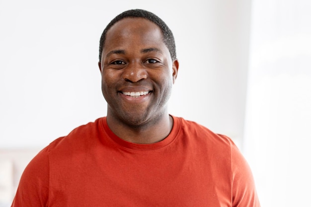 Satisfied middle aged African American man posing looking at camera at home