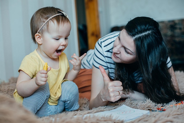 写真 満足した母親が親指を立て、娘がスケッチブックの自分の写真に感動した