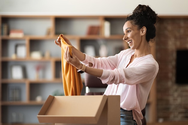 Satisfied pretty woman customer checking her delivery at home