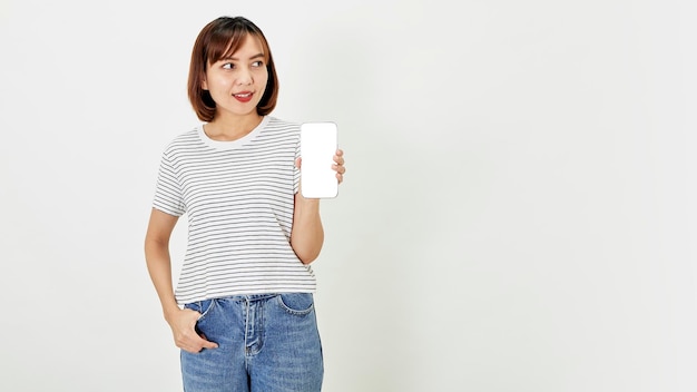 Satisfied smiling asian young woman recommending mobile phone app website company on a smartphone showing screen on white background