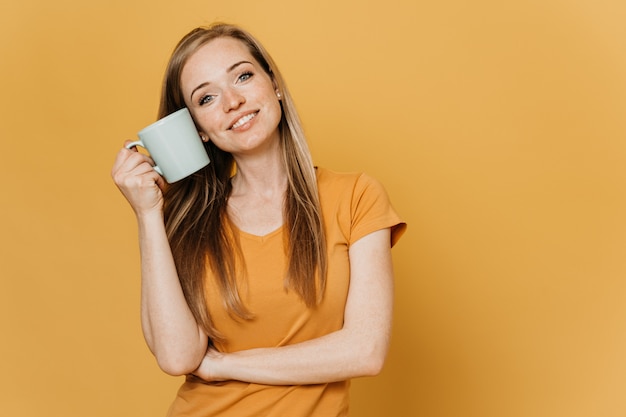 Satisfied young  beautiful redhead woman in orange t-shirt with cute smile in romance mood