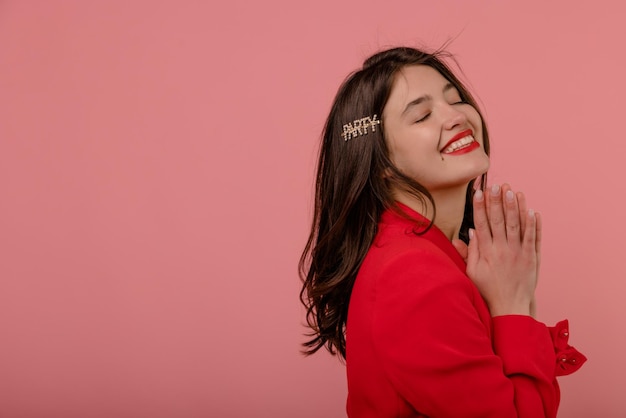 Satisfied young caucasian girl with closed eyes smiles strongly on pink background with space for text Elegant style spring fashion trends