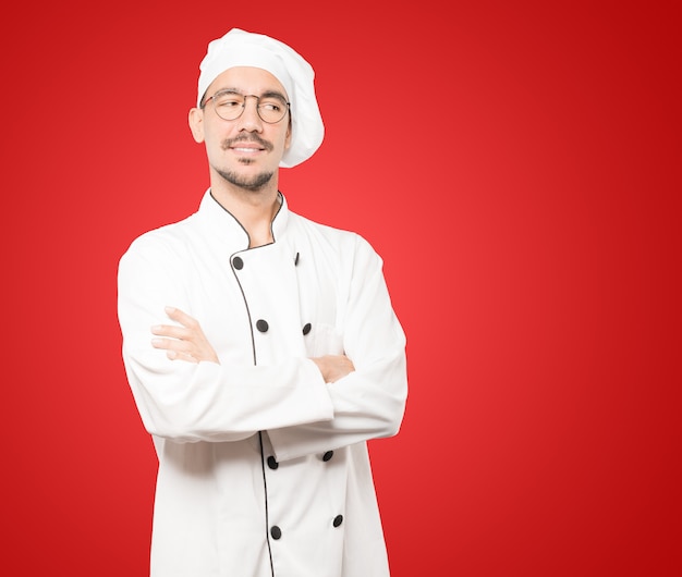 Satisfied young chef with crossed arms gesture