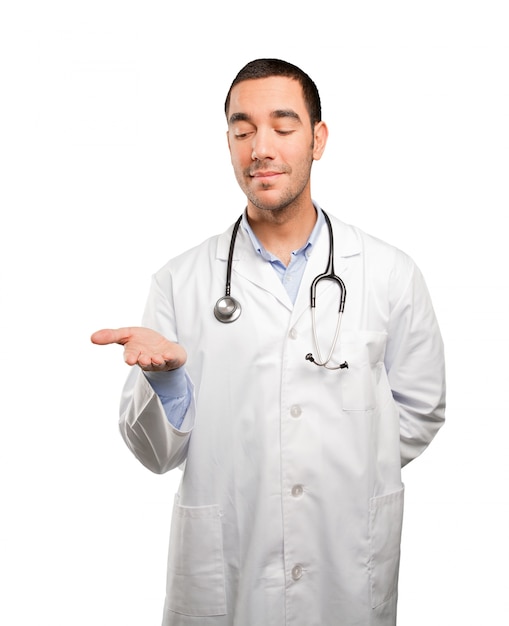 Satisfied young doctor holding gesture