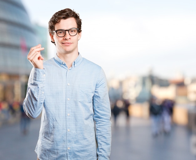 Satisfied young man with a money gesture