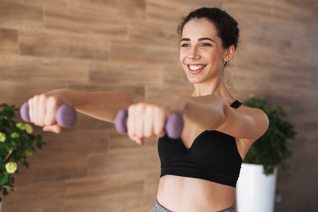 Satisfied young sportswoman doing exercise