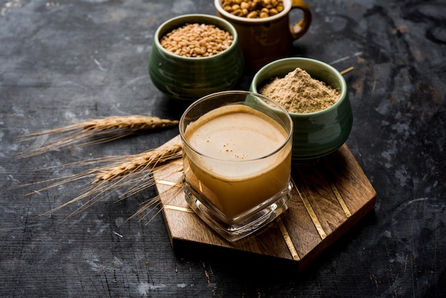 Sattu sharbat is a cooling sweet drink made in summer with roasted black chickpea flour, barley, suger, salt & water. served in a glass. selective focus