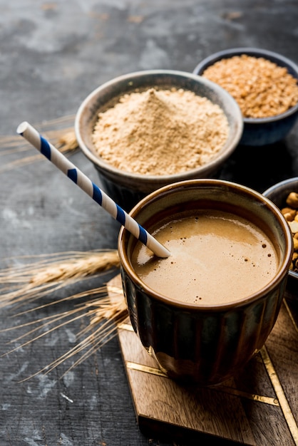 Sattu sharbat is a cooling sweet drink made in summer with roasted black chickpea flour, barley, suger, salt & water. served in a glass. selective focus