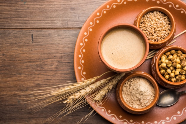 Sattu sharbat is a cooling sweet drink made in summer with roasted black chickpea flour, barley, suger, salt & water. served in a glass. selective focus