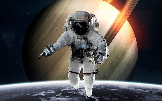 Saturn with astronaut in front of planet. Solar system. Elements of this image furnished by NASA